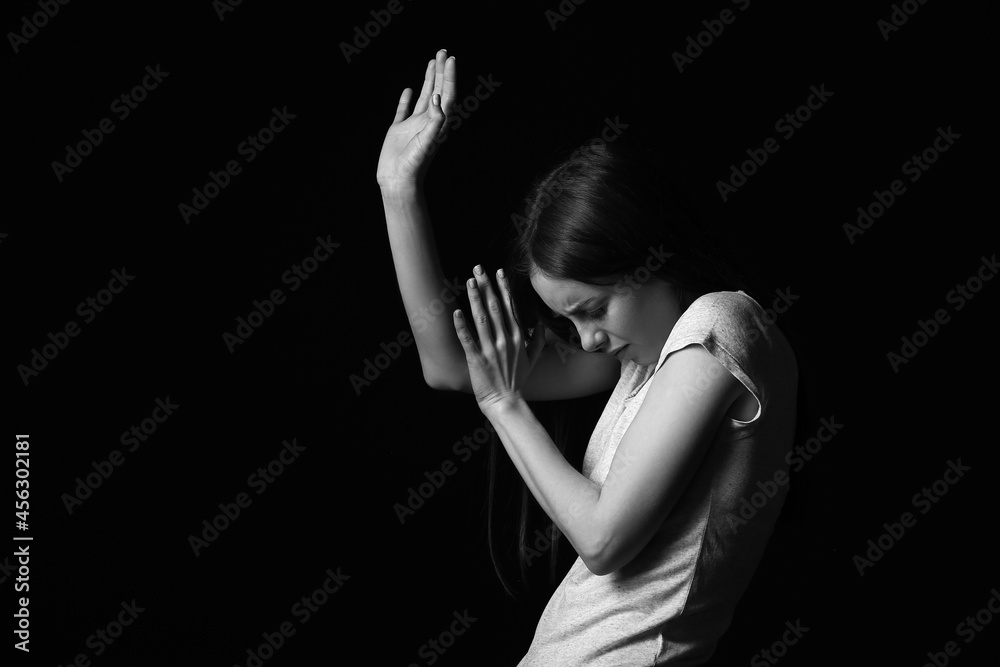 Scared young woman on dark background. Concept of harassment Scared young woman on dark background. Concept of harassment