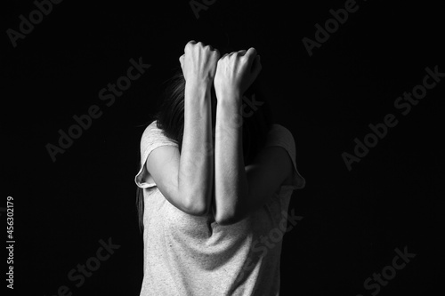 Scared young woman on dark ...