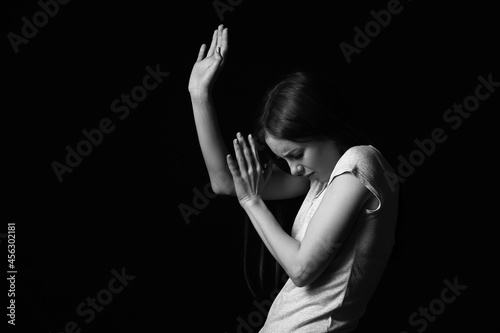 Scared young woman on dark ...