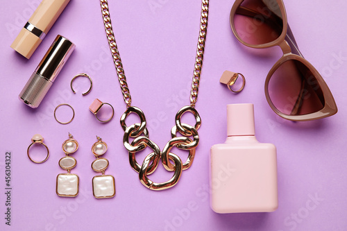 Set of female accessories and cosmetics on color background