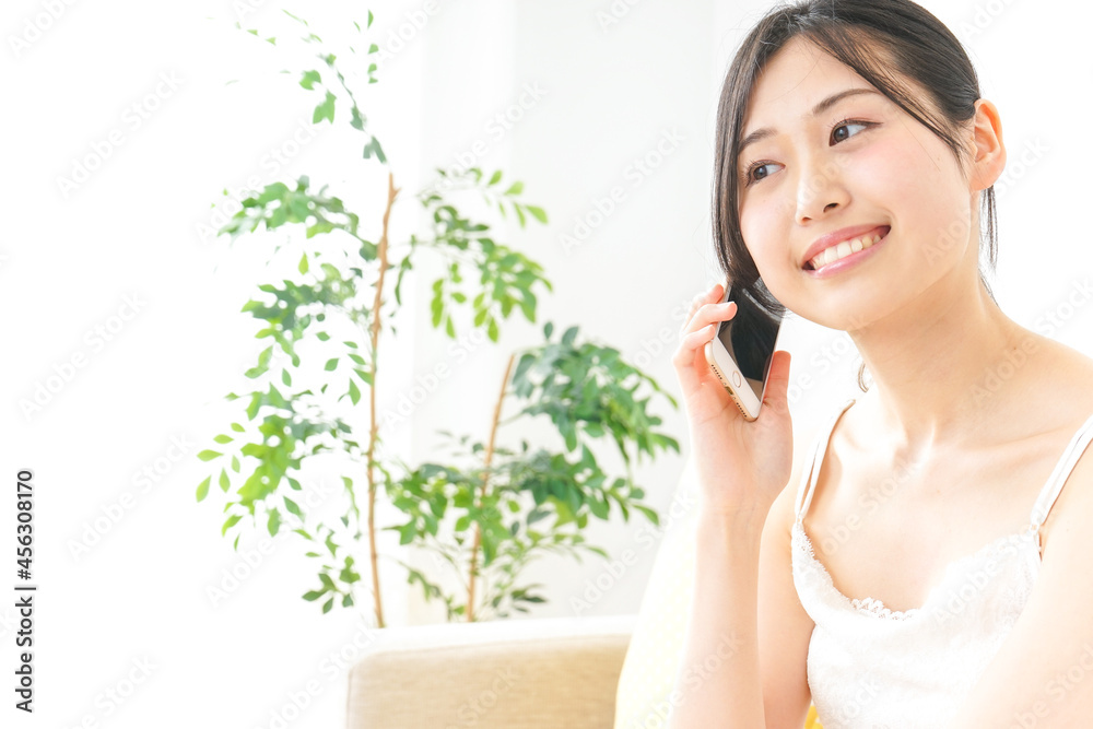 部屋でスマホを使う若い女性 部屋でスマホを使う若い女性