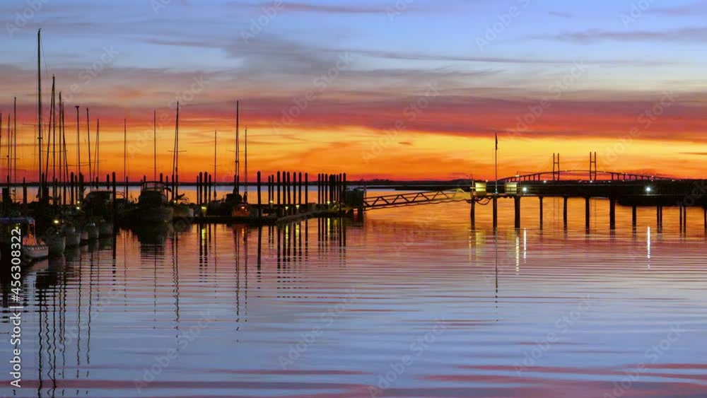 a beautiful sunset over a marina with calm waves passing by a beautiful sunset over a marina with calm waves passing by