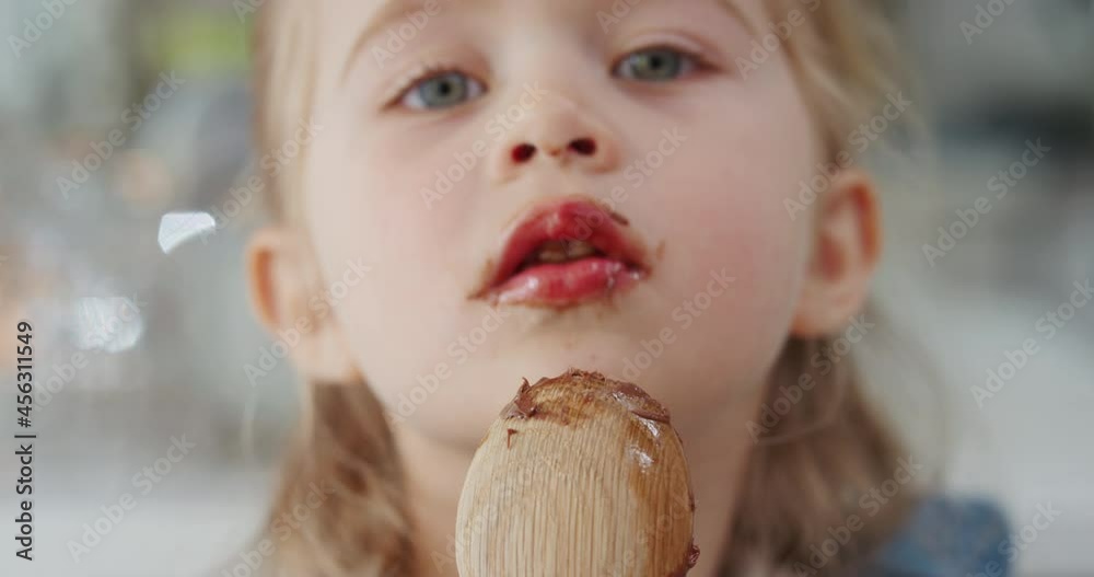 happy little girl licking spoon tasting delicious chocolate pudding enjoying homemade treats in kitchen 4k happy little girl licking spoon tasting delicious chocolate pudding enjoying homemade treats in kitchen 4k