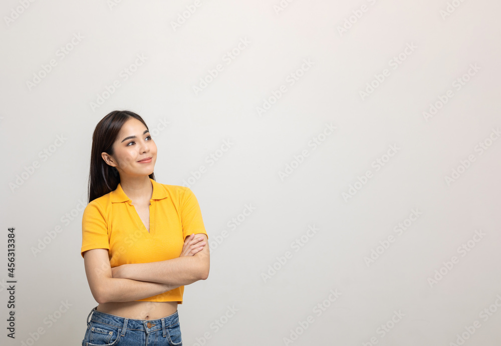 Beautiful asian woman look into blank space. Smiling female wearing yellow shirt on isolated white background. Attractive Teenager girl looking at empty space for text feeling excited and surprised. Beautiful asian woman look into blank space. Smiling female wearing yellow shirt on isolated white background. Attractive Teenager girl looking at empty space for text feeling excited and surprised.