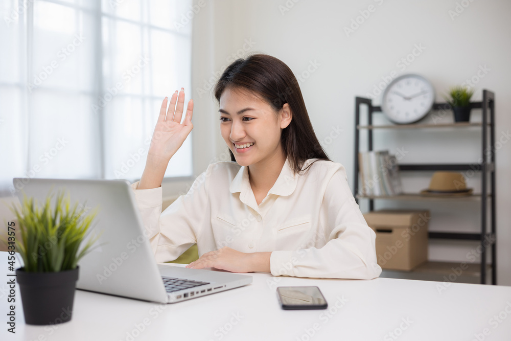 Young asian woman using laptop chatting video conference online sitting in living room at home. Business Woman looking at screen Meeting on social media live steam. Work, learning from home.