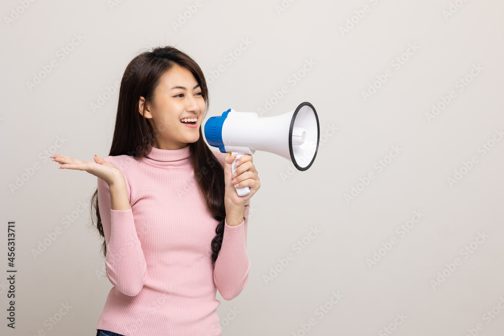 Shout out loud with megaphone. Young beautiful asian woman woman announces with a voice about promotions and advertisements for products at a discounted price. Shopping and fashion concept. Shout out loud with megaphone. Young beautiful asian woman woman announces with a voice about promotions and advertisements for products at a discounted price. Shopping and fashion concept.