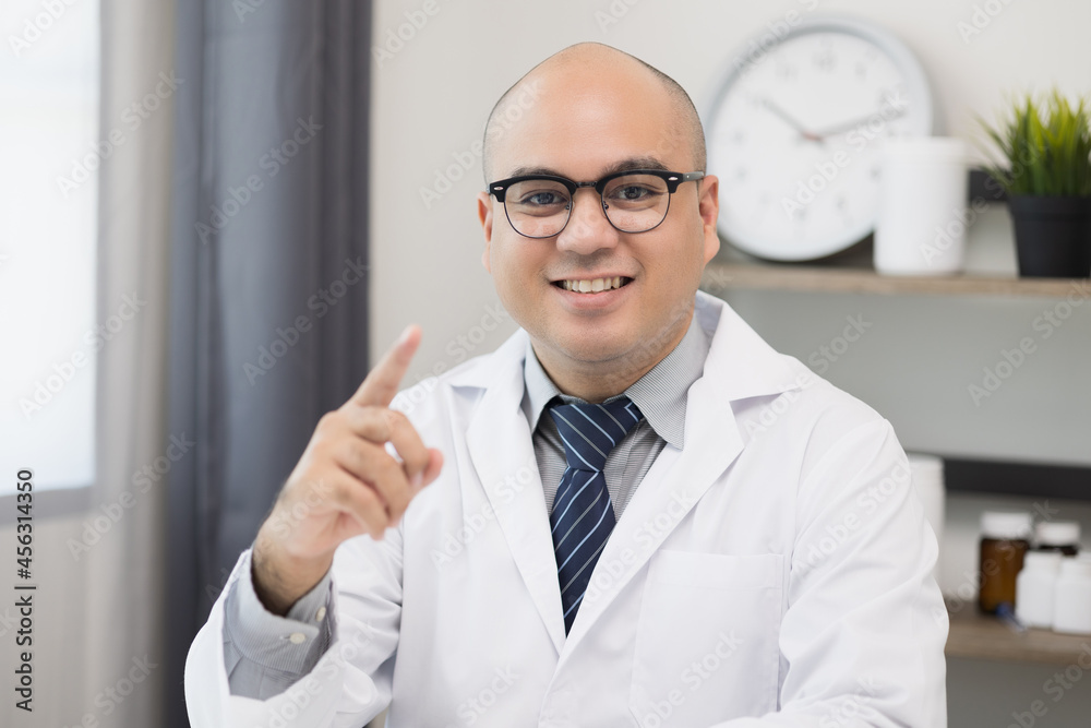 Young asian man doctor works from home working online looking and camera talking with patient Explain about taking medications to treat illnesses. Young asian man doctor works from home working online looking and camera talking with patient Explain about taking medications to treat illnesses.