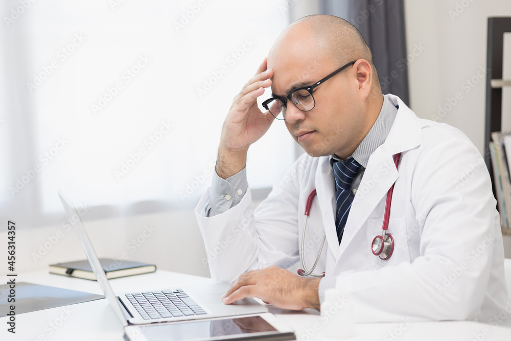 A doctor who works from home is thinking about treating his patients. He is very stressed and headache. He held meetings with patients online. A doctor who works from home is thinking about treating his patients. He is very stressed and headache. He held meetings with patients online.