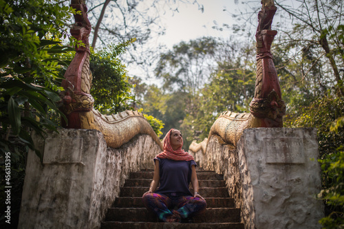 Photography Young woman meditates in a temple in Laos, Asia.