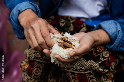 close up of a person holding a bowl of rice