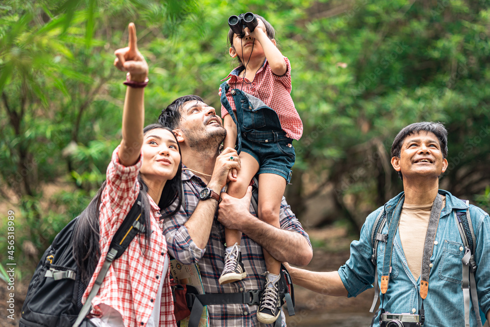 Fototapeta premium A group of young Asians are planning and looking at maps for camping in the forest.Asian and caucasian are backpackers.Tourism, adventure and summer vacation concept
