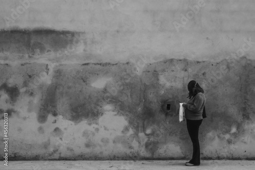 Mulher diante de um muro em época de Pandemia 