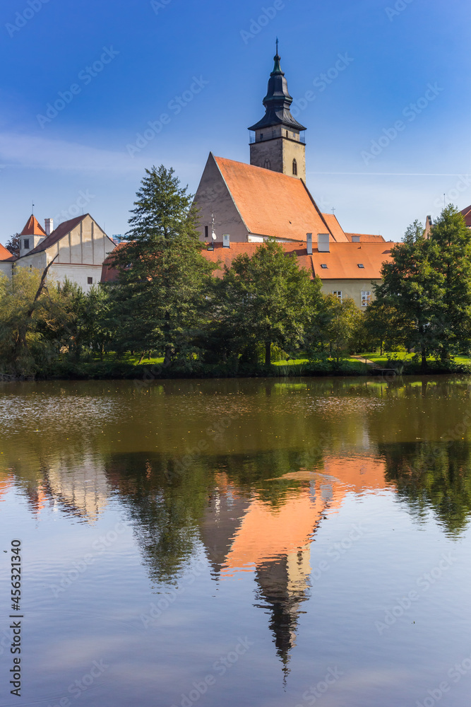 Church tower reflected in the lake in Telc, Czech Republic