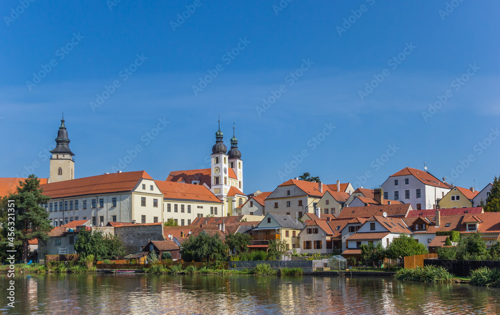 Skyline with castle and old houses reflected in the lake in Telc, Czech Republic
