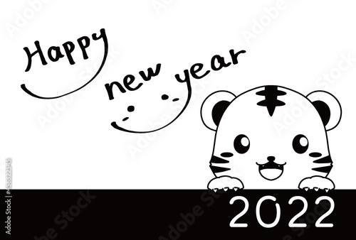 モノクロのひょっこり顔を出すトラと手書きのHappy New Yearの文字の2022年の年賀状