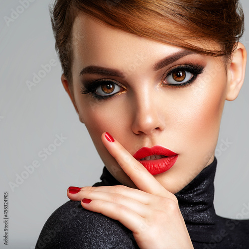 Fotografiet Beautiful brunette girl with red lips and short, slick hair