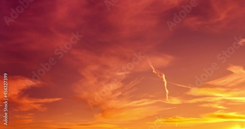 Multicolored sunset sky. Beautiful time lapse at bright autumnal colors with sun reflection. Cirrus clouds and airplanes flying across purple sky. 