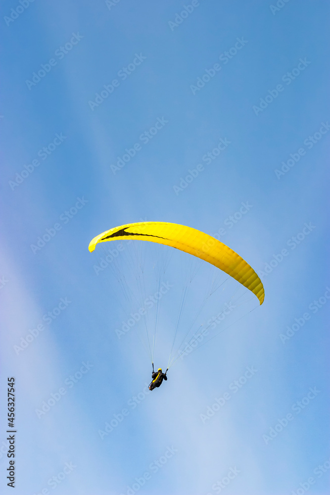 Paraglider flying flying in the blue clear sky Paraglider flying flying in the blue clear sky