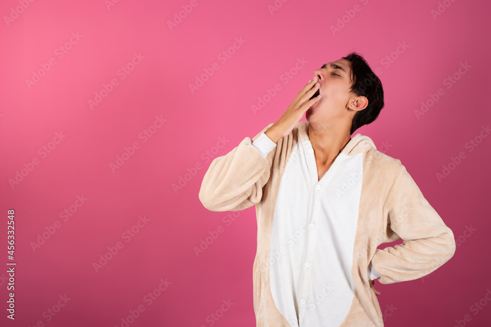 Young and handsome man in pajamas on a pink background. Emotions of guys. Young and handsome man in pajamas on a pink background. Emotions of guys.