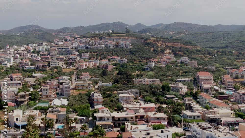 Majestic coastline town of Agia Marina in Crete island, drone side flying view Majestic coastline town of Agia Marina in Crete island, drone side flying view