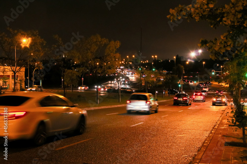 Tráfico nocturno en el barrio de Montecarmelo en Madrid, España. Luces de coche, farolas y semáforos en una noche lluviosa. © AngelLuis