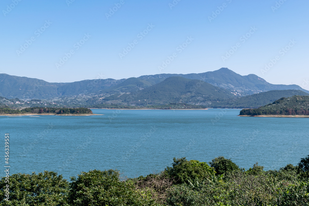 Opposite the lake is the mountain, the sky is blue and the lake water is blue