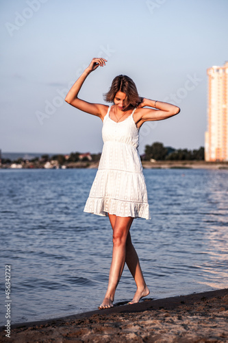 Photos A young woman is standing on the beach