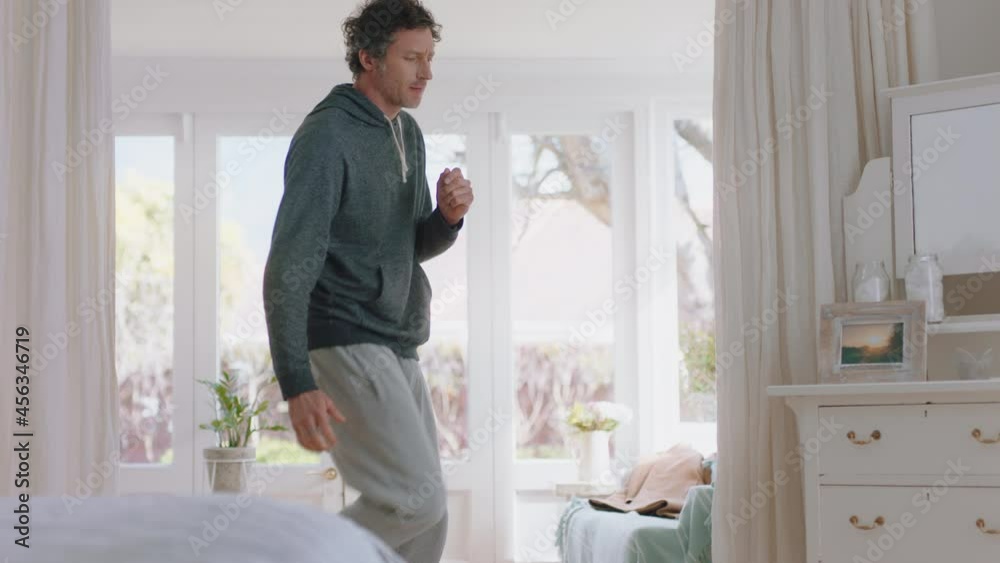 happy young man dancing at home celebrating weekend having fun dance in bedroom wearing pajamas in morning enjoying new day 4k footage