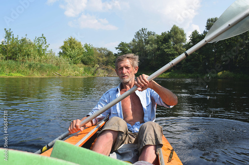 The old man rowing a kayak on the river.