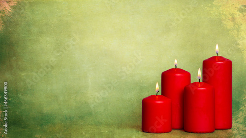 four burning candles on green Background