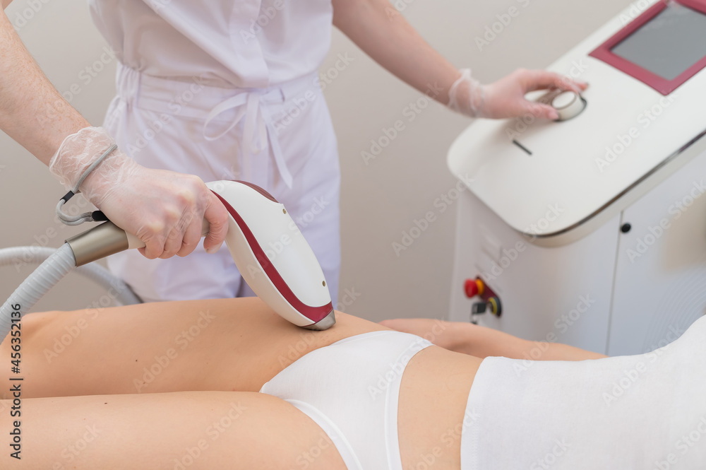 A woman in a professional beauty salon removes unwanted vegetation in the bikini area using laser hair removal A woman in a professional beauty salon removes unwanted vegetation in the bikini area using laser hair removal