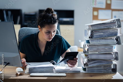 Young Businesswoman Working At Office With Stack Of Folders