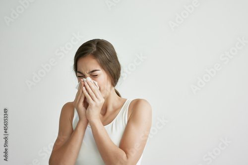 woman in white t-shirt blows her nose in a handkerchief depression infection