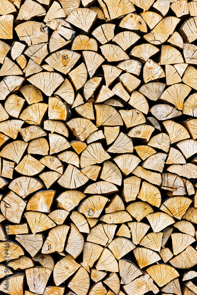 Stacked chopped wood close-up texture. Firewood storage background. Stocks of wooden logs. Chopping wood for a fireplace. Woodpile with firewood with visible wooden texture. Stacked chopped wood close-up texture. Firewood storage background. Stocks of wooden logs. Chopping wood for a fireplace. Woodpile with firewood with visible wooden texture.