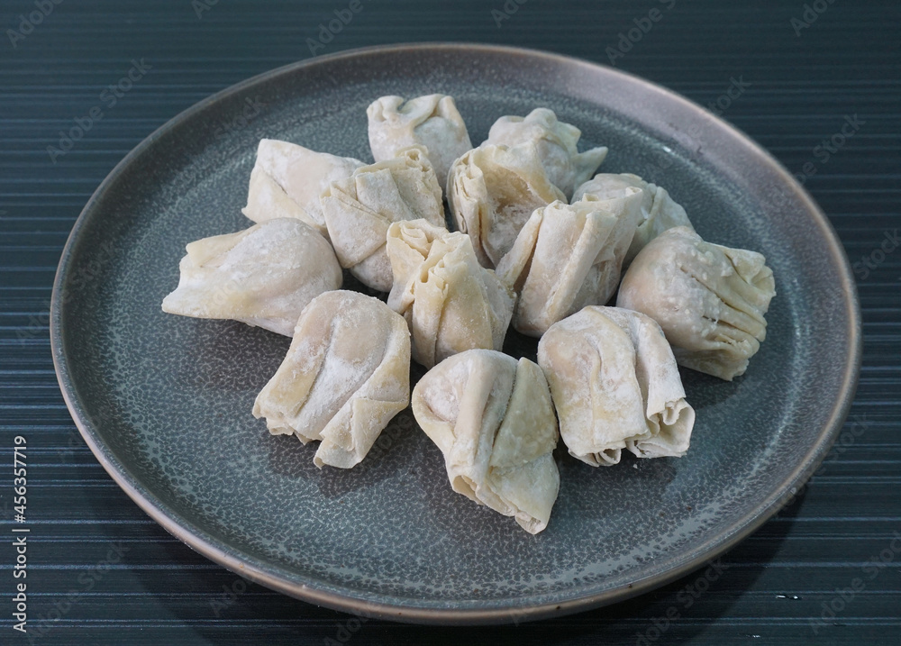 handmade deep fried and boiled pork meat dumpling wanton soup in plate on dark grey wood table asian dim sum halal food restaurant cuisine banquet menu for cafe handmade deep fried and boiled pork meat dumpling wanton soup in plate on dark grey wood table asian dim sum halal food restaurant cuisine banquet menu for cafe