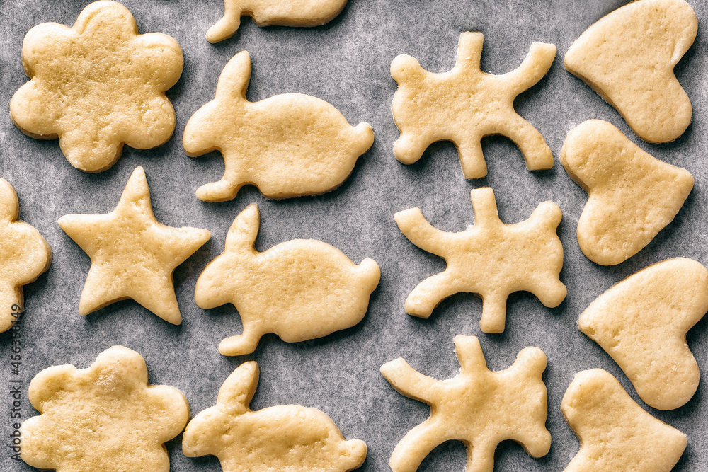 cooking homemade cookies in the form of animals laid out on baking sheet on parchment paper, Christmas or New Year's treats, top view cooking homemade cookies in the form of animals laid out on baking sheet on parchment paper, Christmas or New Year's treats, top view