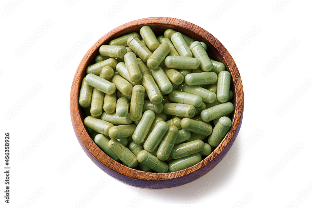 Andrographis paniculata capsules, wooden cup top view isolated on white background - Clipping path Andrographis paniculata capsules, wooden cup top view isolated on white background - Clipping path