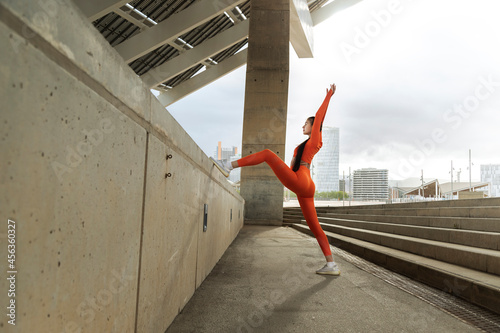 Young woman stretching before workout. Female athlete warming up. Running. Jogging. Modern city.