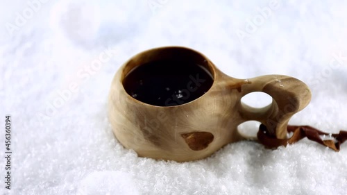 Kuksa. Traditional Finnish wooden cup with tea on the snow. Christmas gingerbread cookie. Hand. High quality FullHD footage