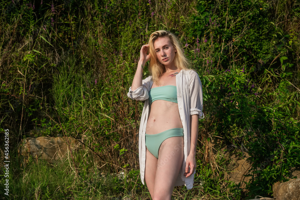 A young girl in a green swimsuit posing in the park. A young girl in a green swimsuit posing in the park.