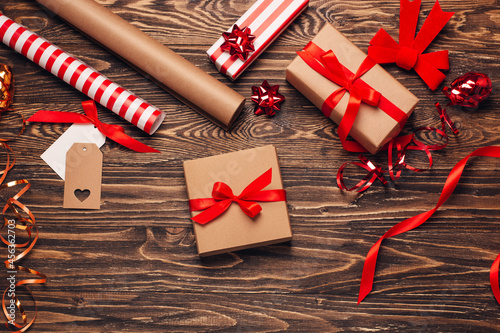 Gift wrapping for christmas and new year. Christmas background with gift boxes, ropes, paper handlebars and decorations on wooden background. Preparing for the holidays. Top view with copy space.
