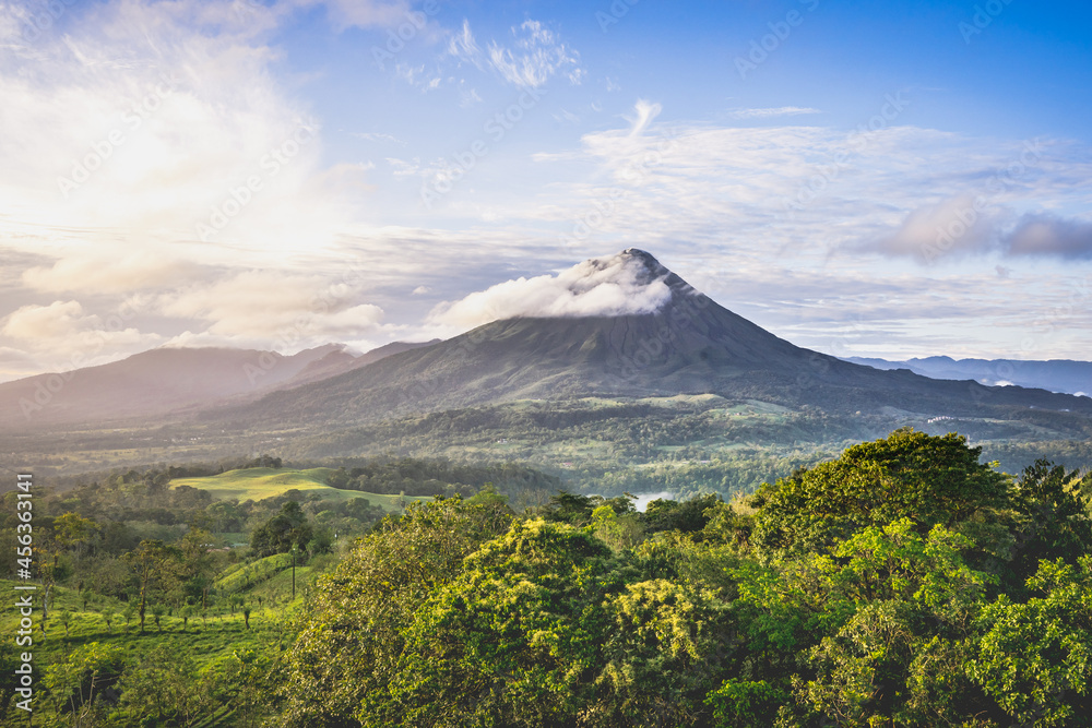 Fototapeta premium Tropical landscape with a volcano rolled by a cloud
