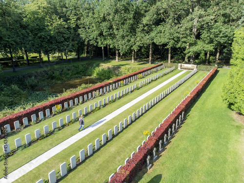 Aerial drone photo of person walking on footpath between war graves at Schoonselhof cemetery graveyard in Wilrijk Antwerp Belgium photo