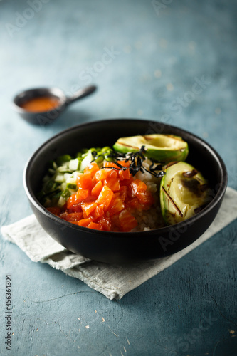 Healthy rice bowl with salmon and grilled avocado