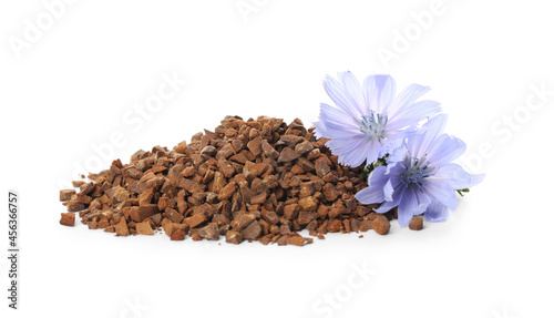 Pile of chicory granules and flowers on white background