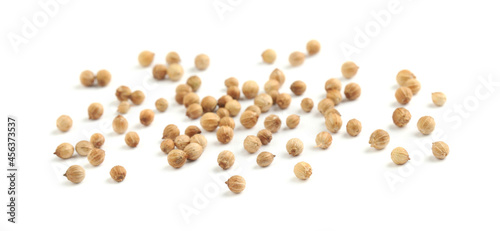 Scattered dried coriander seeds on white background