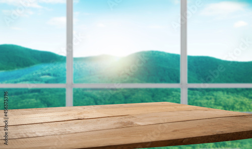 table background free space for your product and blurred landscape of mountains. Blue sky with sunlight. © Egor