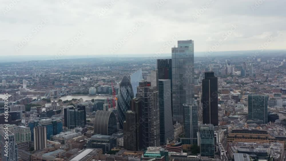 Aerial view of skyscrapers in business centre. Cityscape and Tower Bridge over Thames river in background. London, UK Aerial view of skyscrapers in business centre. Cityscape and Tower Bridge over Thames river in background. London, UK