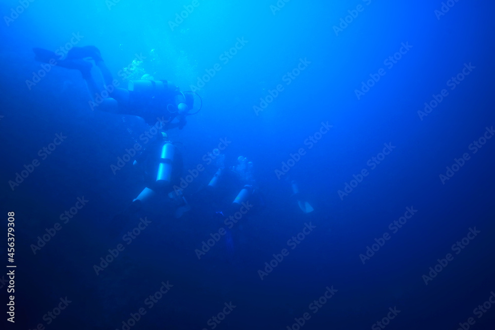 divers in the ocean, underwater sport active recreation in the deep ocean