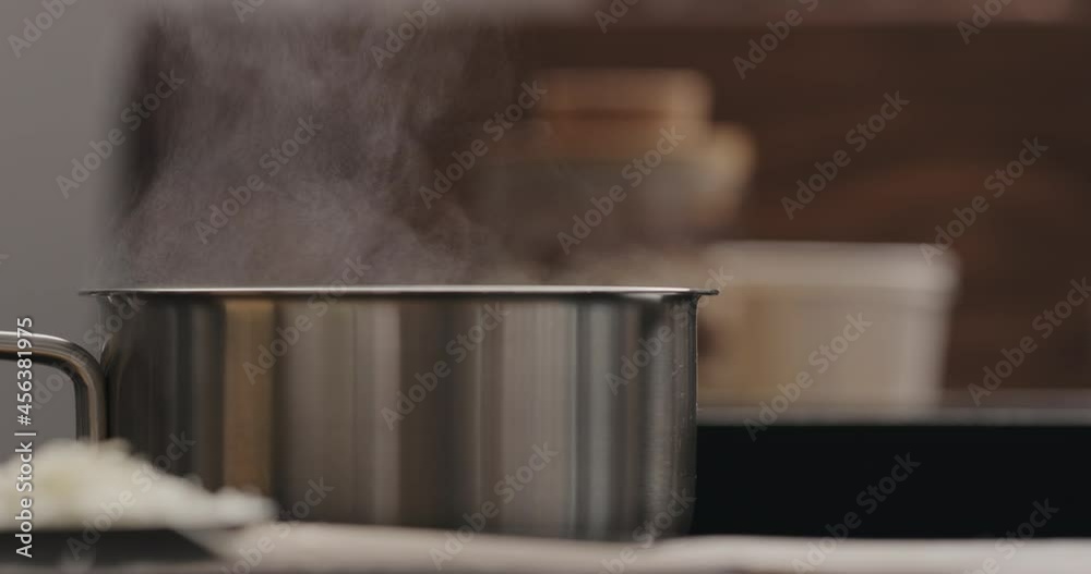 Slow motion steam rising from saucepan with boiling water on stove Slow motion steam rising from saucepan with boiling water on stove
